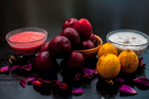 Healthy face mask of plum or aloo Bukhara in a glass bowl on the wooden surface consisting of plum extract, water, curd, and some lemons also for protection against harmful UV rays and sun damage.