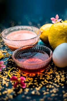 Treatment of dry skin with the help of face mask on a wooden surface consisting of honey, guava pulp, egg yolk, and some oatmeal, well mixed in a glass bowl along with raw ingredients.