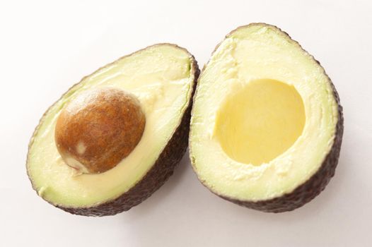 Avocado fruit sliced open to reveal the tasty flesh and large pip for a delicious salad ingredient in vegetarian and vegan cuisine