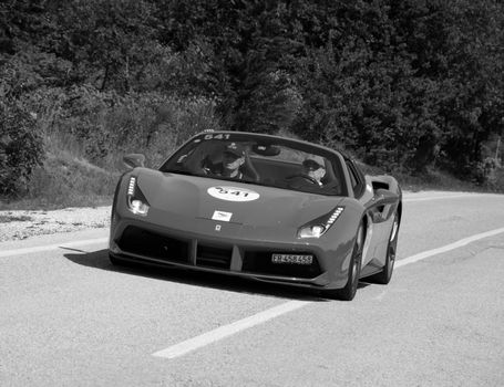 URBINO - ITALY - JUN 16 - 2022 : FERRARI 488 SPIDER 2017 on an old racing car in rally Mille Miglia 2022 the famous italian historical race (1927-1957