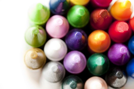 Bunch of colored wax crayons for drawing and art viewed from above looking down on the tops with a small white copy space to the right