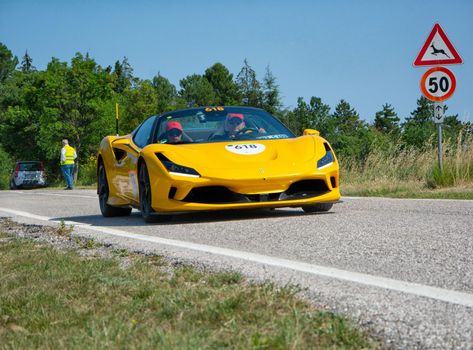 URBINO - ITALY - JUN 16 - 2022 : FERRARI F8 SPIDER 2022 on an old racing car in rally Mille Miglia 2022 the famous italian historical race (1927-1957