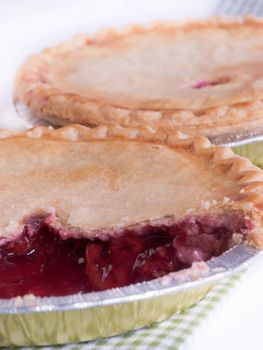 Cherry pie in baking tin with piece missing.