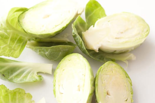 Close up detail of sliced fresh Brussel sprouts cut in half over a white background