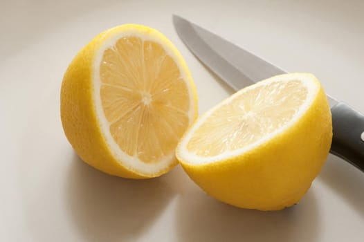 Close-up of cut lemon and knife on white table