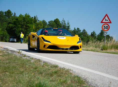 URBINO - ITALY - JUN 16 - 2022 : FERRARI F8 SPIDER 2022 on an old racing car in rally Mille Miglia 2022 the famous italian historical race (1927-1957