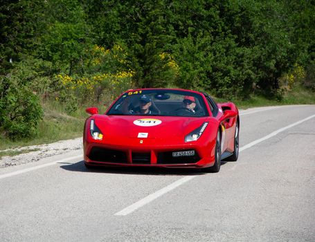 URBINO - ITALY - JUN 16 - 2022 : FERRARI 488 SPIDER 2017 on an old racing car in rally Mille Miglia 2022 the famous italian historical race (1927-1957