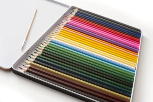Selective focus tight crop on case full of various colored pencils with white copy space above them