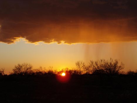 storm clouds breaking over a beautiful orange sunset