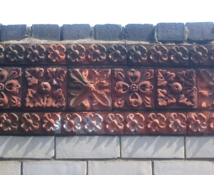 a brick wall with decorative floral motif pattern bricks