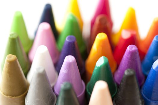 Close up of numerous colorful wax crayon tips or points in an art and creativity concept