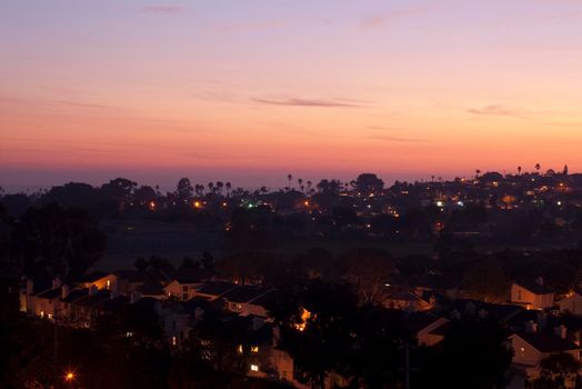 golden orange light of sunset illiminates beach side suburbs