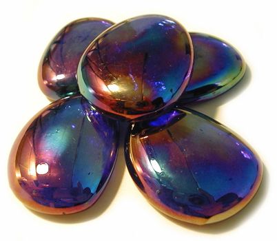 Five smooth iridescent stones with a colourful sheen used as an ornament for interior decor or as massage stones for s spa, on a white background
