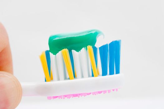 close up on a toothbrush with green toothpaste on it