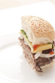 Half cut cheeseburger sliced through the center with a thick juicy beef patty and salad trimming s with a slice of cheese