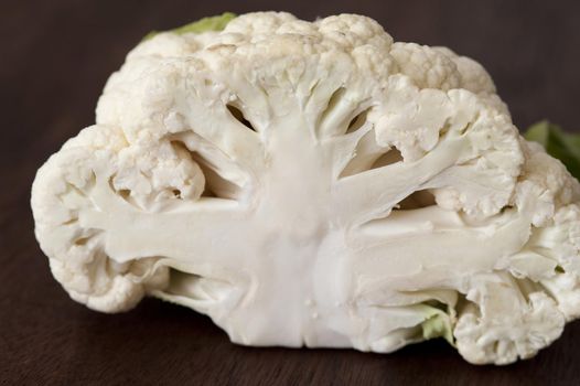 White cauliflower cut in half, viewed in close-up on dark background