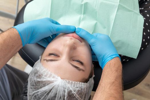 Male dentist looks at a jaw of female patient. Showing the bite to the doctor