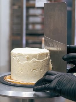 professional baker decorating a chocolate and cream cake with salty caramel