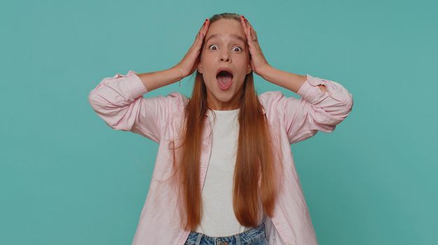 Oh my God, Wow. Excited amazed girl looking surprised at camera with big eyes, shocked by sudden victory game winning, lottery goal achievemen, good news. Child kid on blue studio background indoor