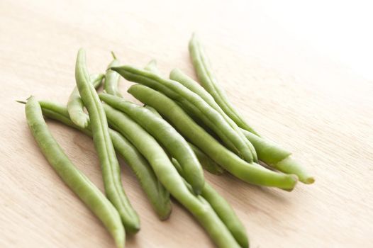 Pile of green runner beans on wooden table
