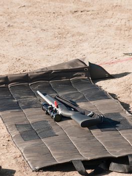 Rifle on the shooting mat with safety on.