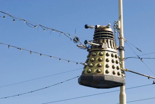 Hiding behind the sofa when Blackpool illuminations comes on the tv? Homage to the doctor who character attached to street a pole against a blue sky