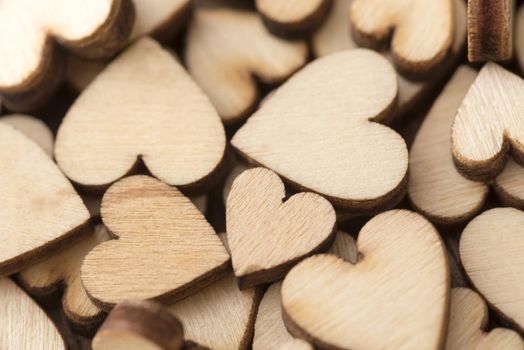 Background pattern and texture of a jumble of different sized wooden hearts in a concept of love, romance and Valentines Day