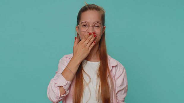 I will not say anyone. Frightened teen girl closing her mouth with hand, looking intimidated scared at camera, gestures no, refusing to tell terrible secret, unbelievable truth. Young female child kid