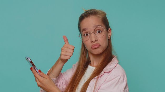 Pretty teen female child kid using smartphone typing new post on web, browsing, searching, addiction of social networks, show thumbs up like, positive feedback, recommends wifi cellular connection 5G