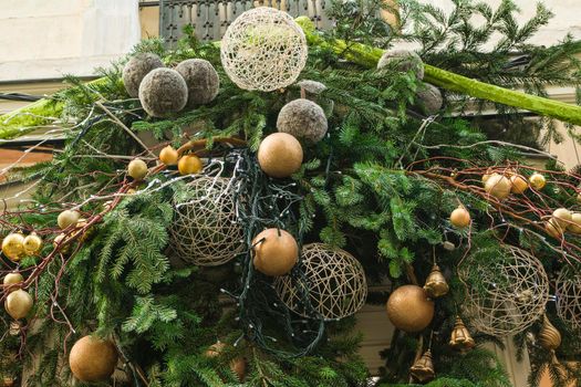 Decoration made from fir branches and golden balls on the wall of a shop