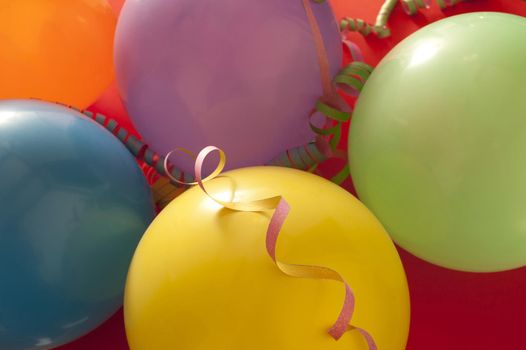 Party or celebration background of colorful balloons and spiral streamers in a close up full frame view from above