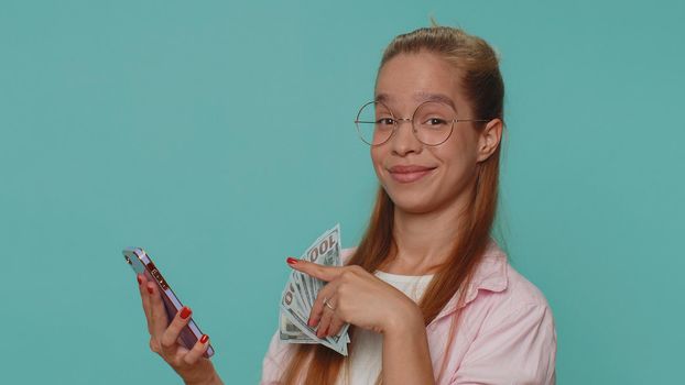Pretty teen female child kid using smartphone typing new post on web, browsing, searching, addiction of social networks, show thumbs up like, positive feedback, recommends wifi cellular connection 5G