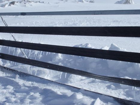 icicles forming on a mountain top snowdrift fence