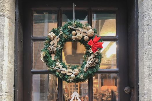Christmas wreath with small miniatures on a glass door