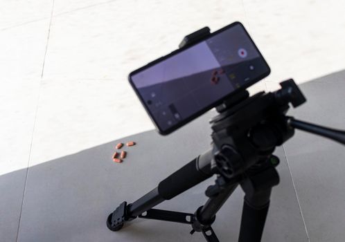 Close up shot of a phone on tripod capturing medicine on the surface