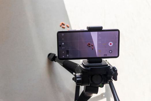 Close up shot of a phone on tripod capturing medicine on the surface