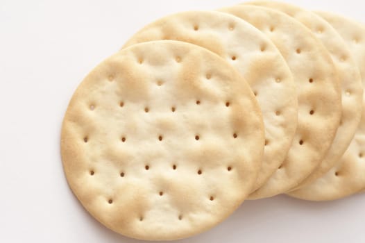 Close-up of several crusty crackers lying on white background