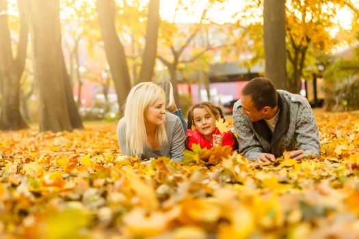 Happy beautiful family playing and laughing on autumn walk