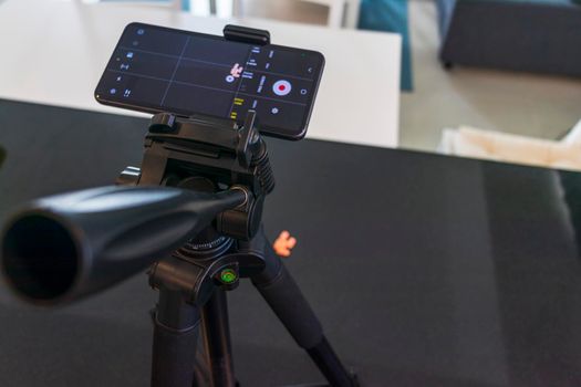 Close up shot of a phone on tripod capturing medicine on the surface