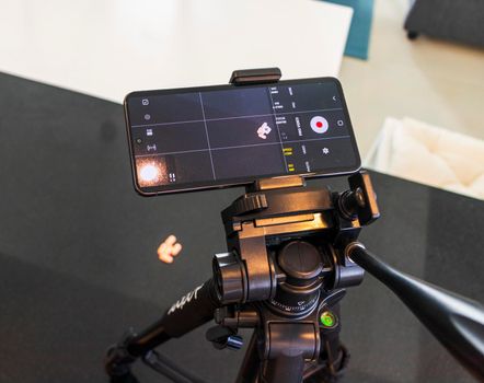 Close up shot of a phone on tripod capturing medicine on the surface