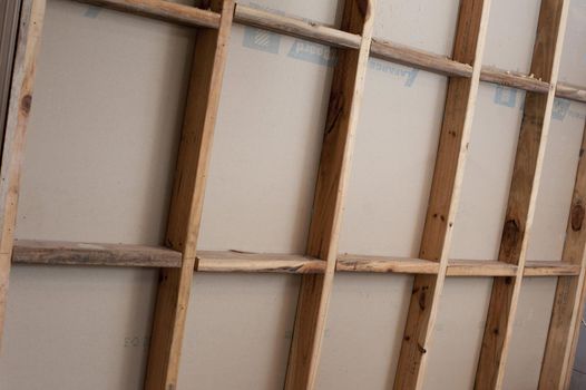 Open stud wall of wooden frame house under construction, viewed in full frame from the side