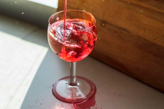 Shot of a red liquid being poured in to the wine glass.