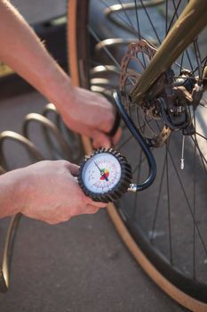 Vertical close up of a cyclist using air pump inflating bicycle tire