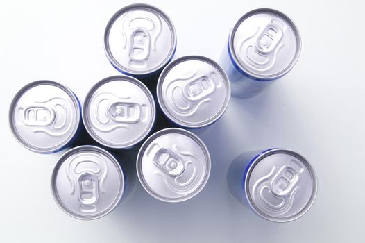 Unopened drinks cans viewed from above looking down onto the aluminium lids over a white background