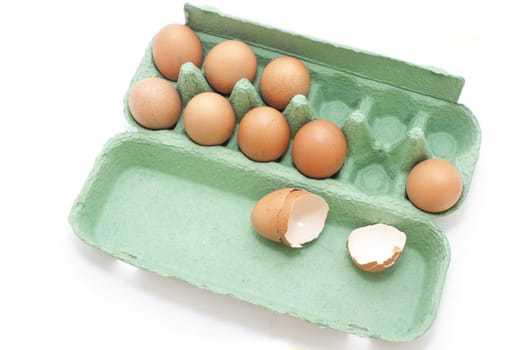 Fresh Brown Eggs on a Green Tray with Cracked Open Egg Shells Isolated on White Background