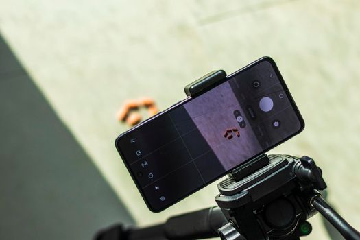 Close up shot of a phone on tripod capturing medicine on the surface