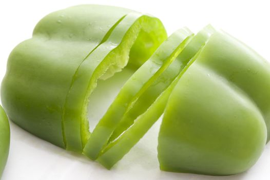 Halved and sliced fresh green sweet bell pepper or capsicum for use as an ingredient in a salad or for cooking