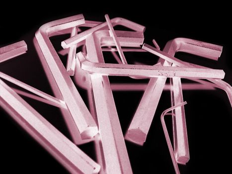 Reverse exposure red tinted set of various sized hex wrenches over black background