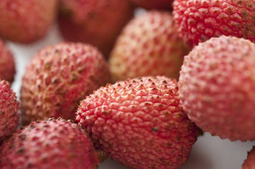 Close up Plenty of Healthy Fresh Sweet Pink Lychee Fruits on a White Table
