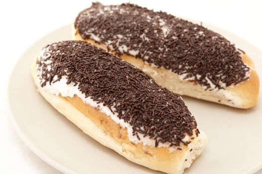 Freshly buns topped with chocolate sprinkles on a plate for a tasty dessert or refreshments for a coffee break